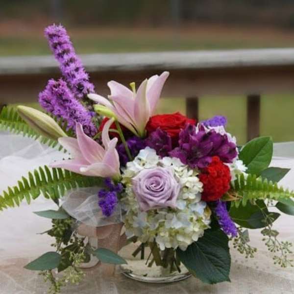 Bouquet of lilies, roses, and purple flowers with greenery