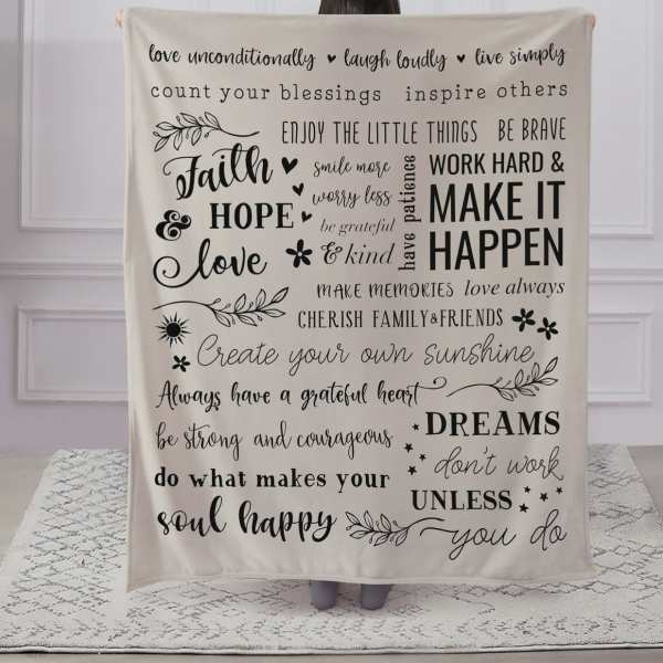 Person holding a cream blanket with black inspirational text