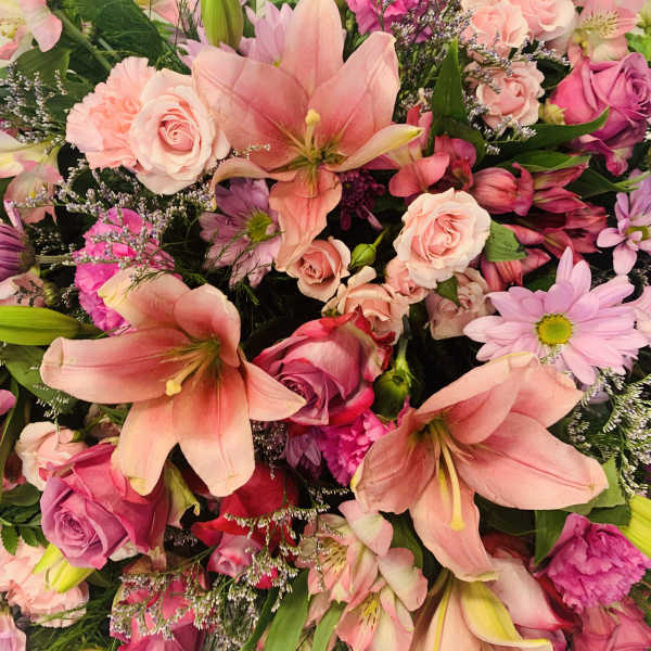 Pink and peach bouquet with lilies, roses, and daisies