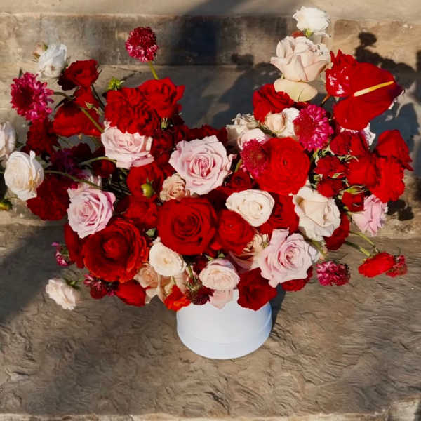 Bouquet of red, pink, and white roses in a white vase