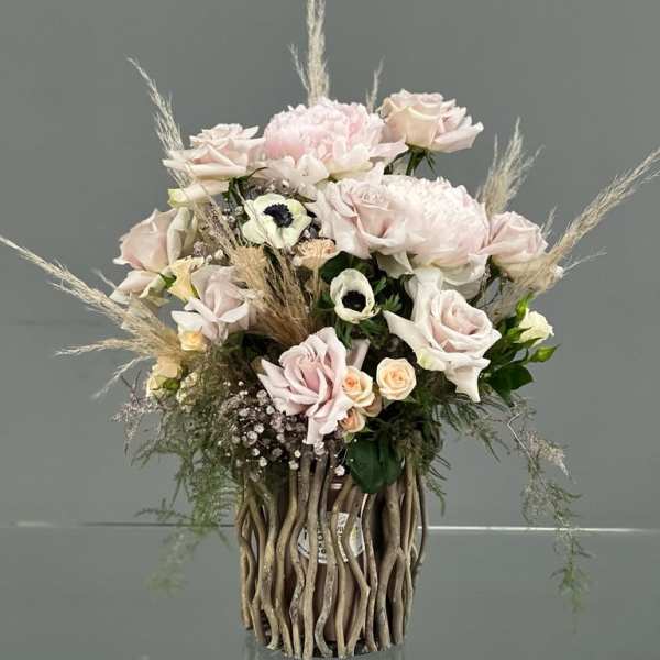 Blush rose arrangement in a tall decorative vase