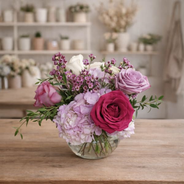 Pink and lavender roses with hydrangea in a clear glass bowl