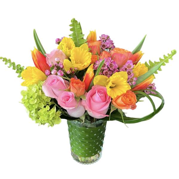 Colorful bouquet of roses and daffodils in a green glass vase