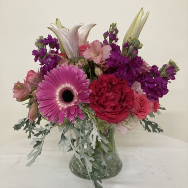 Pink and purple mixed bouquet in a clear glass vase