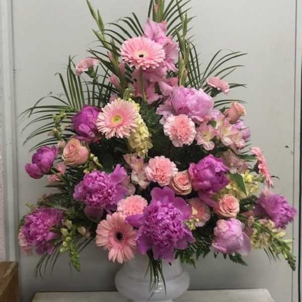 Pink and purple floral arrangement in a white vase