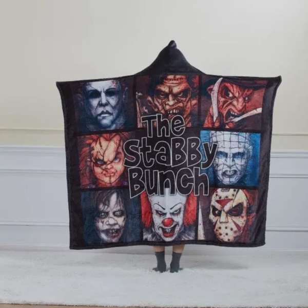 Person holding a horror-themed blanket with multiple masked faces