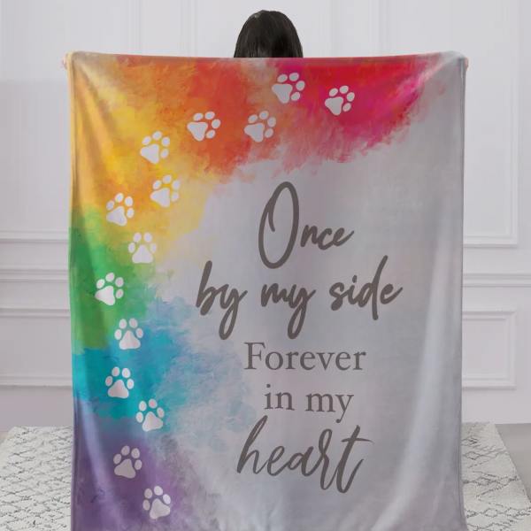 Rainbow memorial blanket with paw prints and the words "Once by my side Forever in my heart"