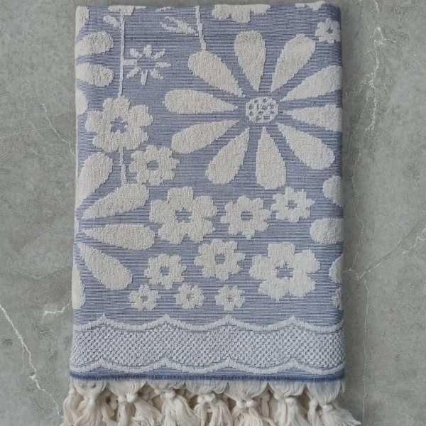 Folded blue and white floral-patterned textile with tassel fringe