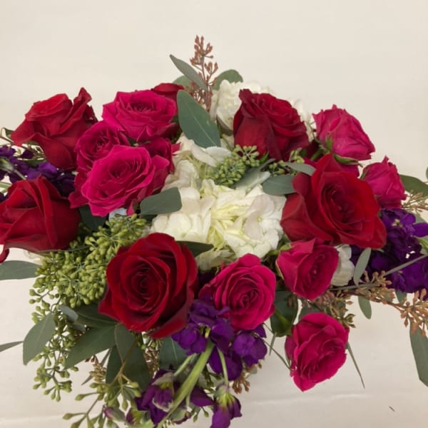 Bouquet of red and pink roses with white flowers and purple accents