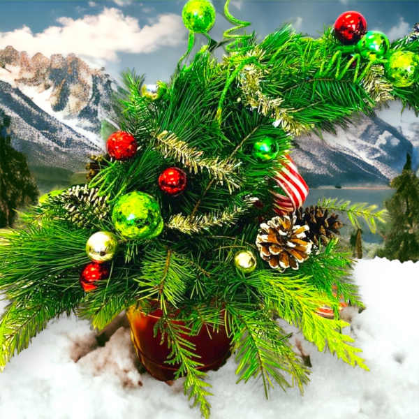 Christmas tree arrangement with ornaments and pinecones in a pot