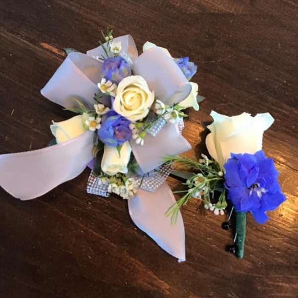 Small corsage and boutonniere with white and blue flowers and lavender ribbon