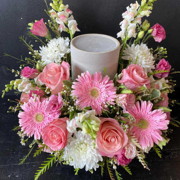 Pink and white floral wreath around a gray candle holder