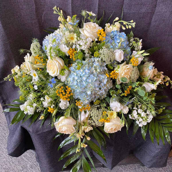 Large bouquet of white and blue flowers with yellow accents