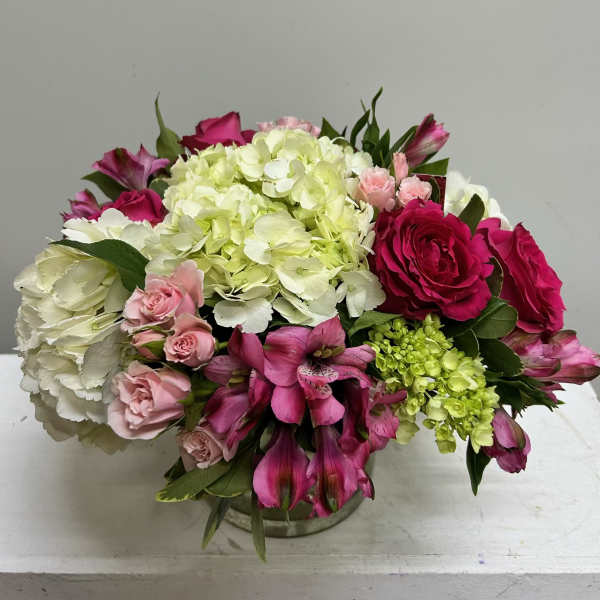 Mixed bouquet of pink roses, hydrangeas, and alstroemeria in a low vase