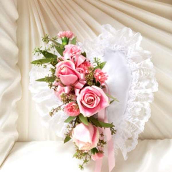 Pink rose corsage with white ruffled trim and ribbon