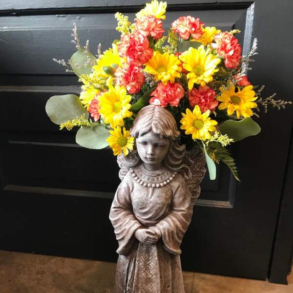 Flower arrangement on a girl statue with yellow and red blooms