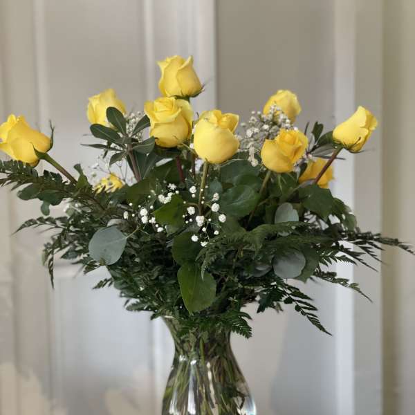 Yellow roses arranged in a clear glass vase