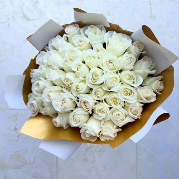 Bouquet of white roses wrapped in gold and white paper