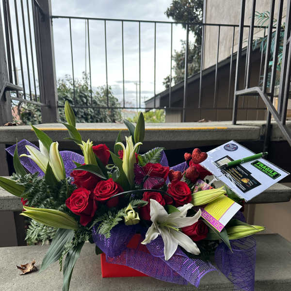 Bouquet of red roses and white lilies with purple wrap