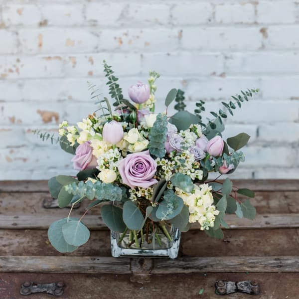 Lavender roses and tulips in a square glass vase