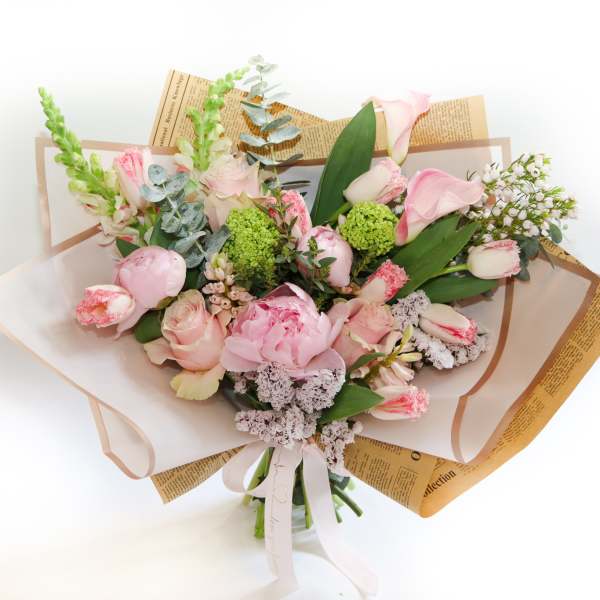 Bouquet of pink flowers wrapped in paper with a ribbon