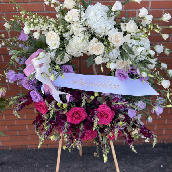 Large floral standing arrangement with white and pink blooms on an easel