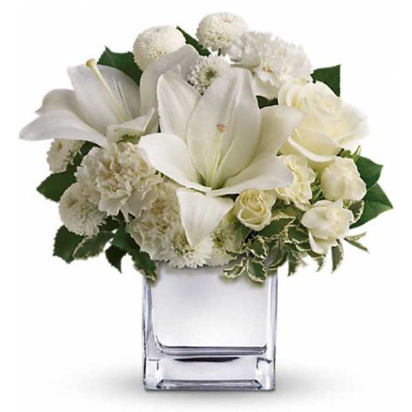 White flowers arranged in a clear square vase
