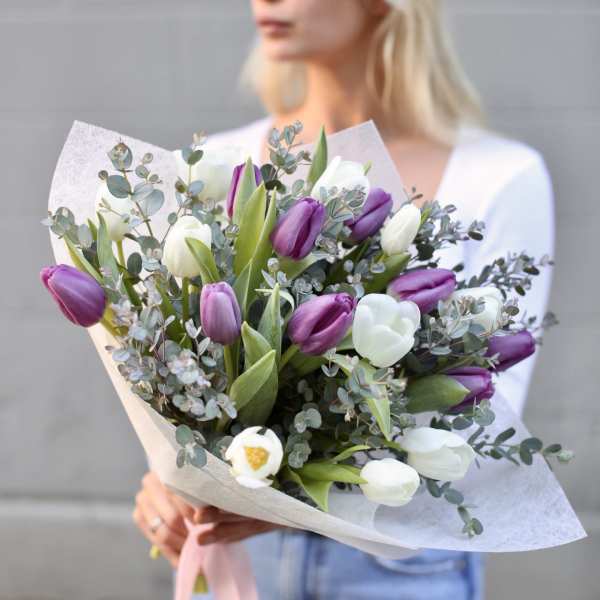 Bouquet of purple and white tulips wrapped in paper