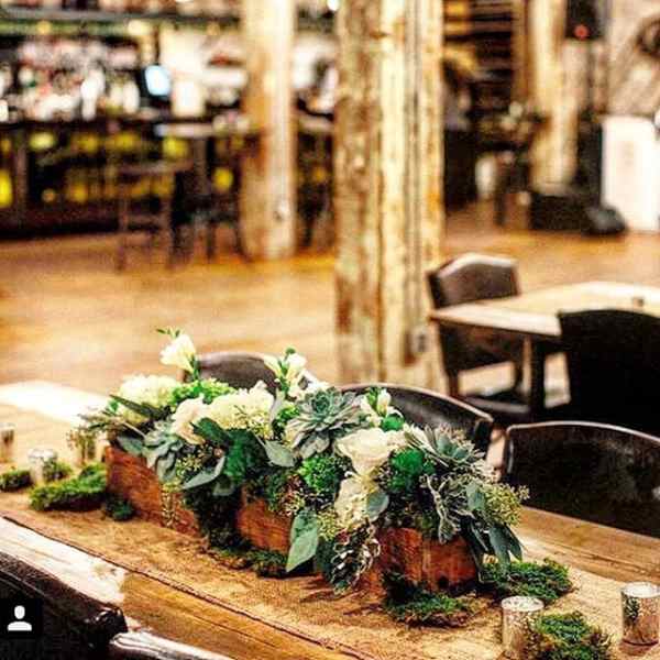 Low floral centerpiece with white blooms and succulents in wooden containers