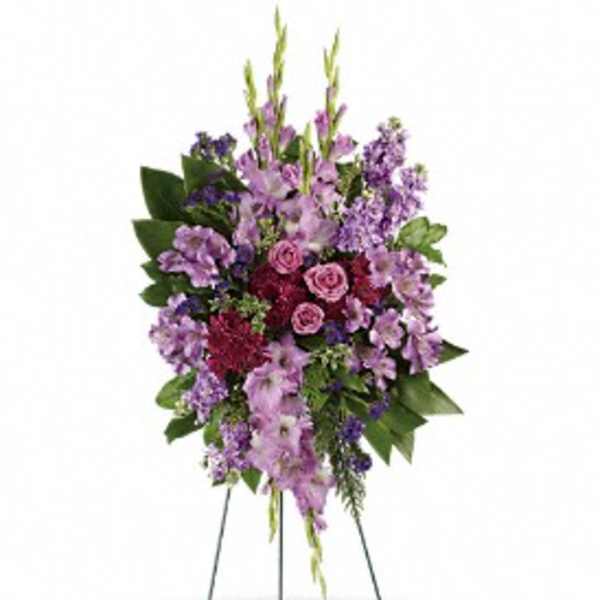 Standing floral spray with purple flowers and pink roses on a wire easel