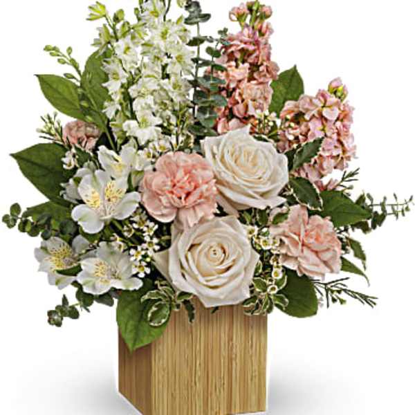 Pink and white floral arrangement in a wooden cube vase