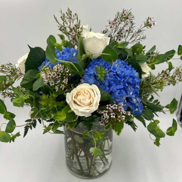 Blue hydrangeas and white roses in a glass vase