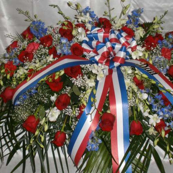 Large red, white, and blue floral wreath with ribbon bow