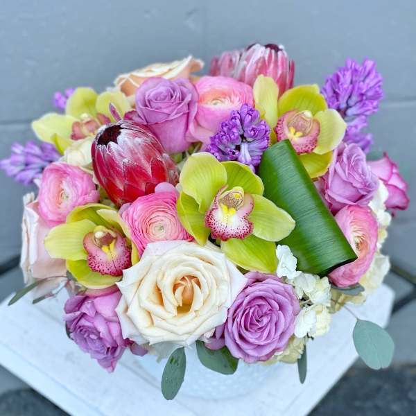 Bouquet of pink and white roses with green orchids and purple flowers
