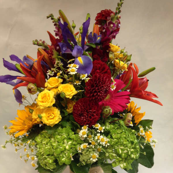 Colorful mixed bouquet in a burlap-wrapped vase