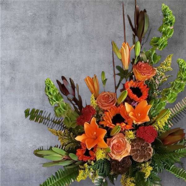 Orange and peach floral arrangement with lilies and roses