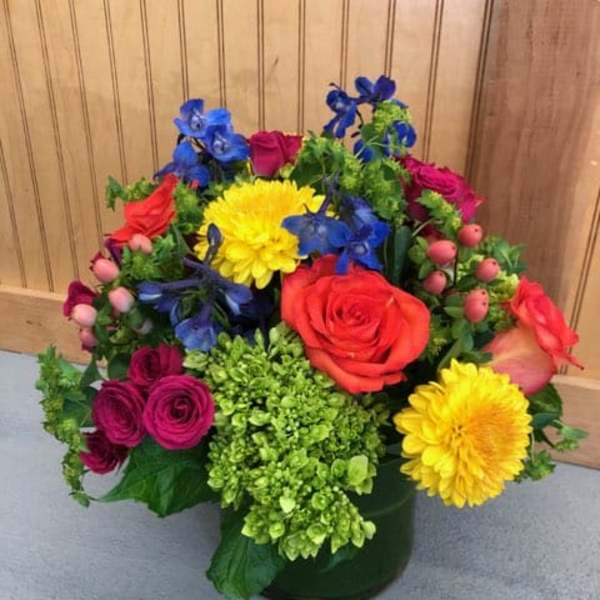 Colorful mixed flower arrangement in a dark vase