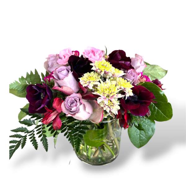 Mixed pink and burgundy flowers in a glass vase