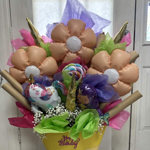 Birthday balloon bouquet in a yellow cone with unicorn balloons and tissue paper