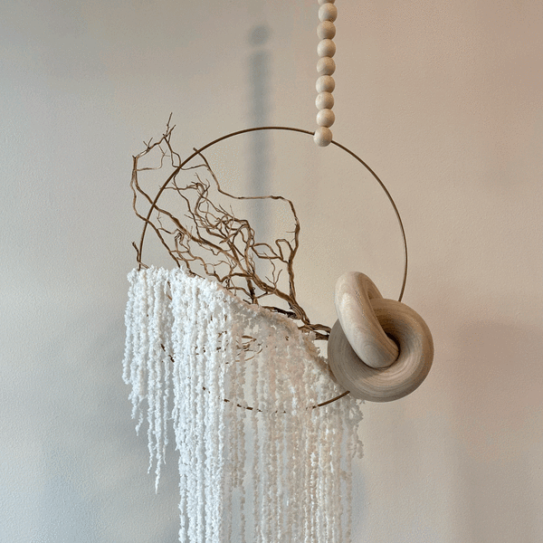 Minimal wall hanging with white cascading texture and wooden rings