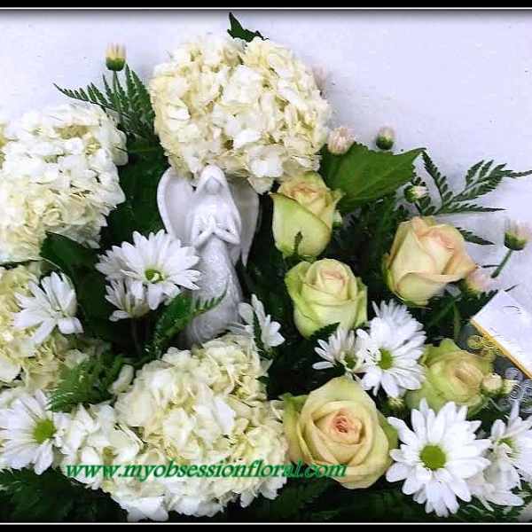 White hydrangeas and pale roses with daisies in a floral arrangement