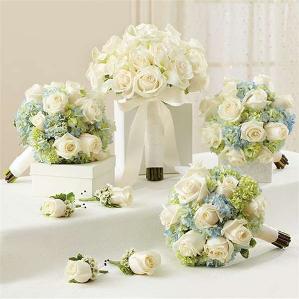 White rose bouquets with pale blue hydrangeas and matching boutonnieres