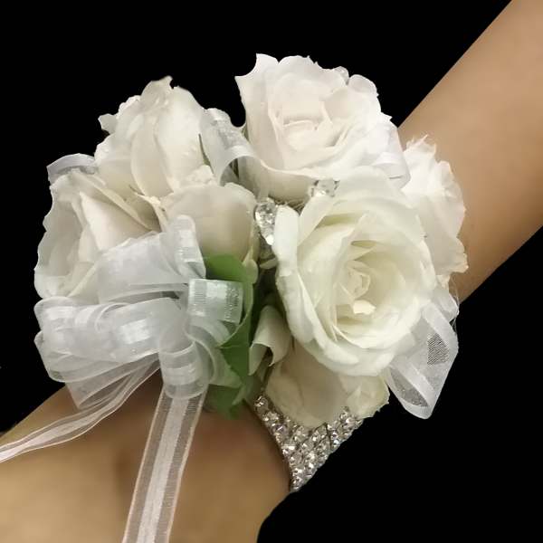 White rose wrist corsage with sheer ribbon on a rhinestone bracelet band.
