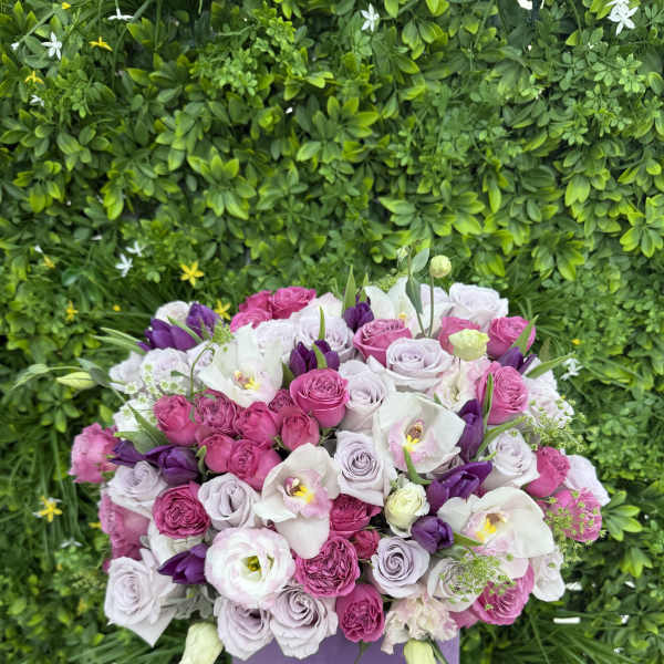 Pink, lavender, and white roses in a purple hat box