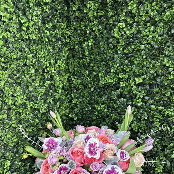 Pink and lavender rose bouquet with orchids in a gold vase