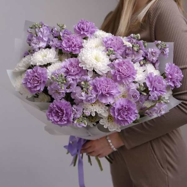 Bouquet of purple and white flowers wrapped in pale paper