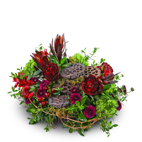 Mixed floral arrangement with red blooms and lotus pods