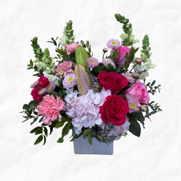 Pink and white mixed flower arrangement in a gray vase