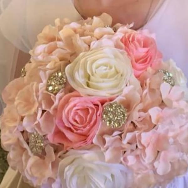 Bride holding a pastel bouquet of roses and hydrangeas with glitter accents
