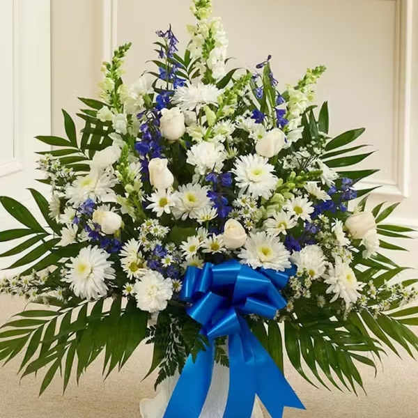 White and blue floral standing arrangement with a blue ribbon